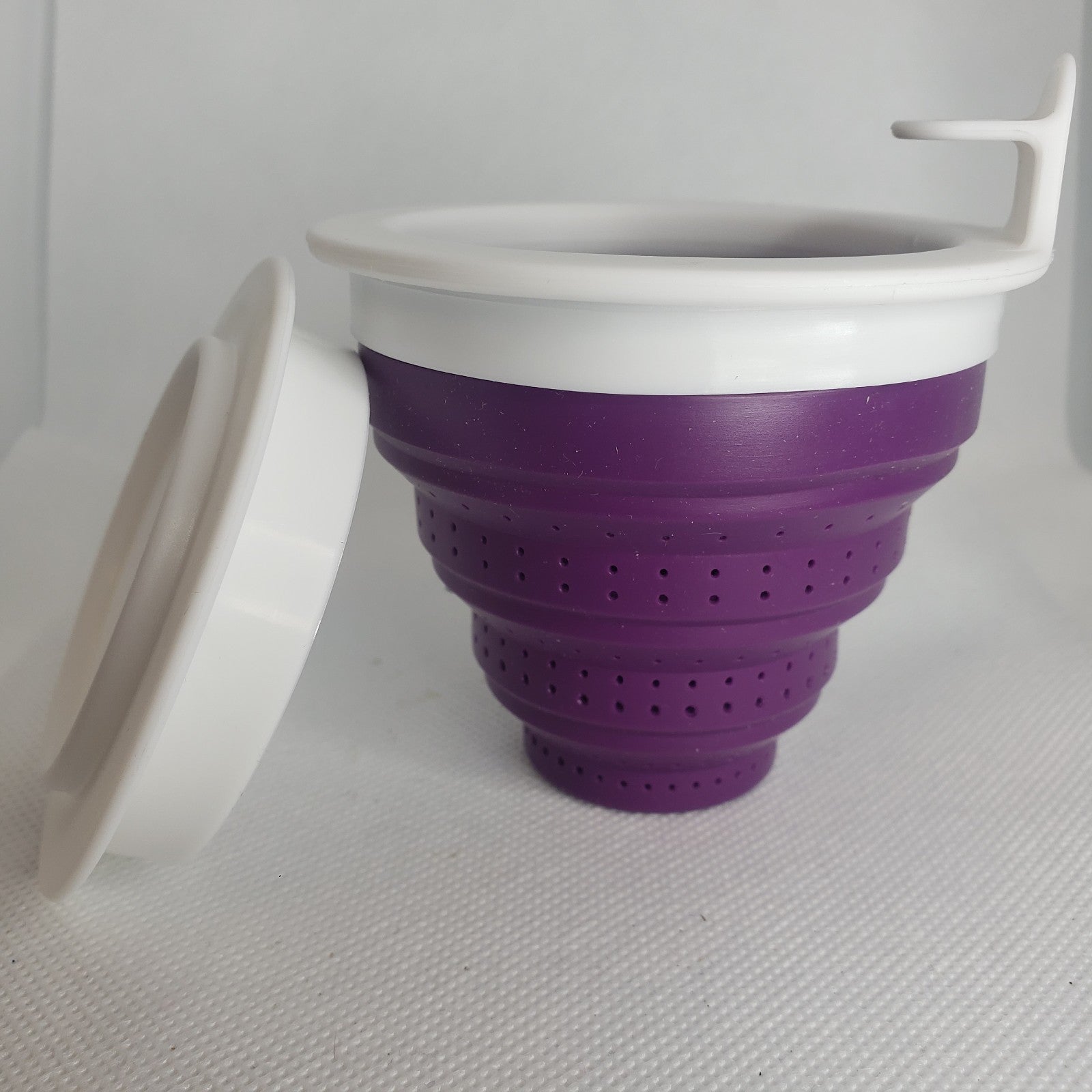 Image of a violet colored silicone tea steeper on a white background